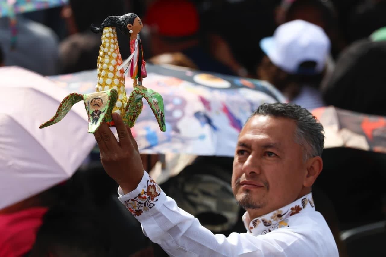 Asistente muestra una figura alusiva a Claudia Sheinbaum durante el acto en el Zócalo