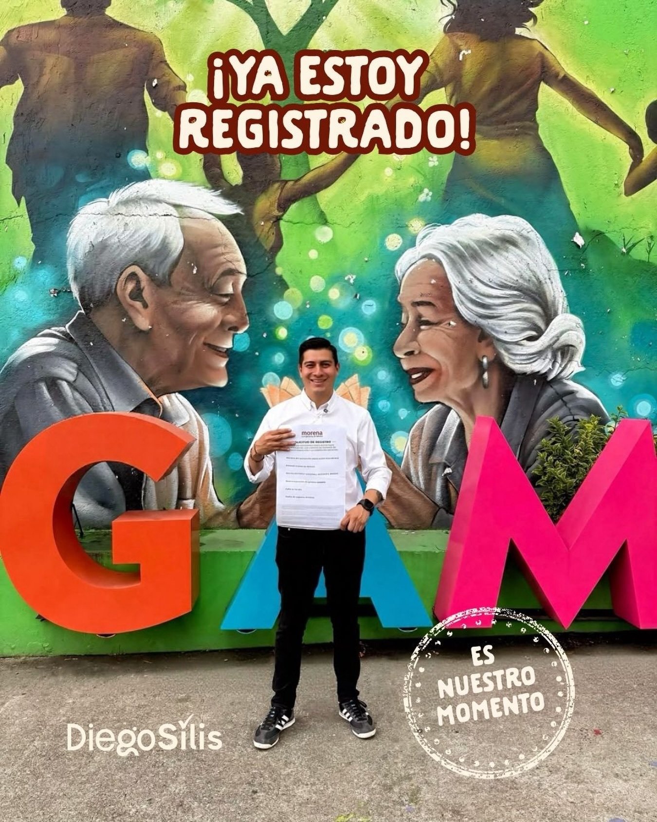 Diego Silis sostiene un documento con el encabezado Solicitud de registro ante un mural con letras GAM